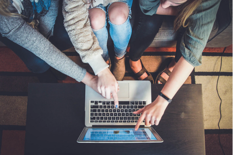 three students pointing to a laptop screen