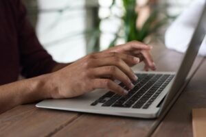 hands typing on a laptop